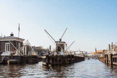 Gün batımında Amsterdam 'ın estetik kanalları, sudan manzara, nehirden modern asma köprü manzarası. Amsterdam 'da romantik kanal gezisi -12.04.2023