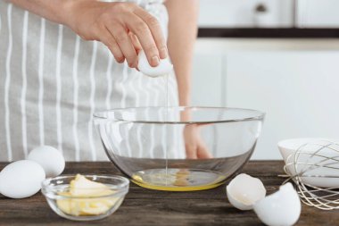 Fırıncı ya da aşçı çiğ yumurtayı kaseye koyar. Pişirmek ya da ekmek için hamur pişirmek, yumurtalarla kahvaltı hazırlamak, sabah rutini. Ev yapımı mı, el yapımı mı?.