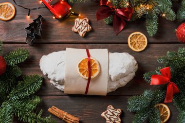 Badem ezmesi ve meyveli Noel çöreği, Noel için Alman meyveli pasta, karanlık arka plan, Noel ışıkları, kuru meyveler.