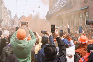 Krallar Günü 'nü kutlayan kalabalık turuncu kıyafetler giyer ve müzik performansı kaydeder. Hollanda, Amsterdam, 27.04.2023
