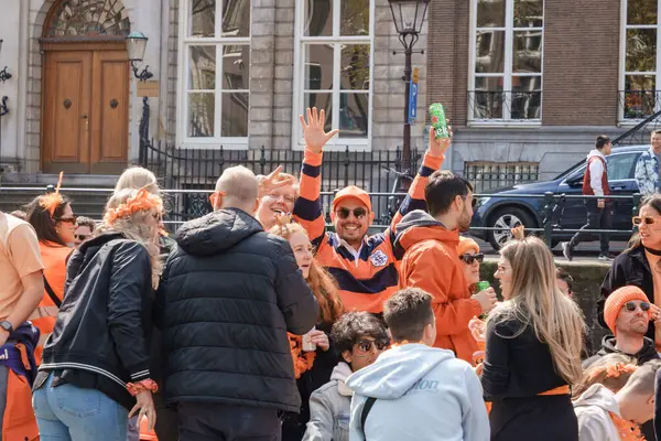 Turuncu giyinmiş mutlu parti katılımcıları Amsterdam kanallarında Kral Günü 'nün tadını çıkarıyorlar Hollanda, Amsterdam, 27.04.2023