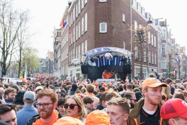 Sokak dansında kalabalık, Krallar Günü 'nü kutlayan turuncu giysiler giyiyor Hollanda, Amsterdam, 27.04.2023