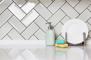 Modern mutfak tezgahında sabun, sünger ve döşeme tezgahı var..