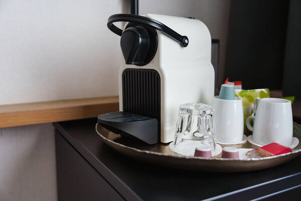 coffee machine with cups and pods placed on a kitchen counter, ready for brewing fresh coffee