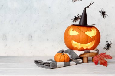 Cadılar bayramı balkabağı feneri. Cadı şapkası ve eşarp takıyor. Sonbahar süslemeleri.