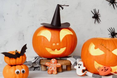 Dost canlısı Cadılar Bayramı Jack-O 'Fenerleri oyulmuş balkabakları, neşeli ürkütücü kurabiyeler, asılı örümcekler