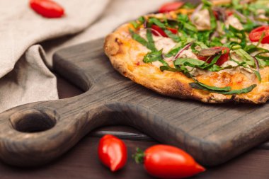 Ançüezli İtalyan pizzası ve ahşap bir tahta üzerinde servis edilen taze hindi.