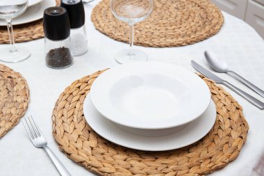 Restoranda sofra kur, beyaz tabaklar, dokuma tabaklar, zarif çatal bıçak takımı, romantik randevu ya da güzel yemek deneyimi için mükemmel.