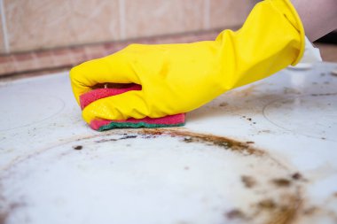 Sarı eldivenleri eline al kirli sobayı sünger ve deterjanla ovala, yağ ve lekeleri temizle.