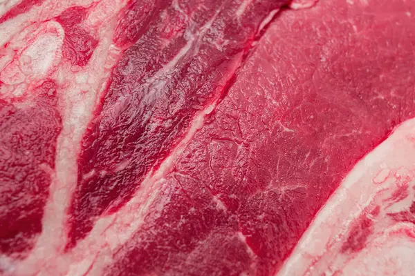 stock image A close-up view of fresh, raw beef showcasing its rich red texture and marbling.