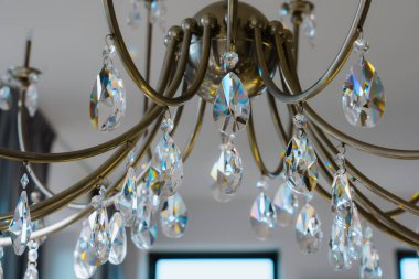 Cam kristalli zarif bir avize. Işıkta parıldıyor, modern ev içi.