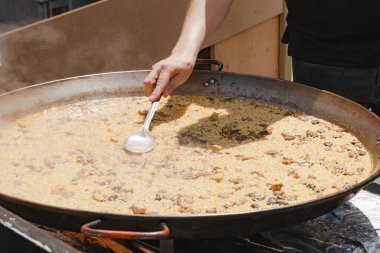 Şef geleneksel İspanyol pilav tabağını buharda pişirdi.