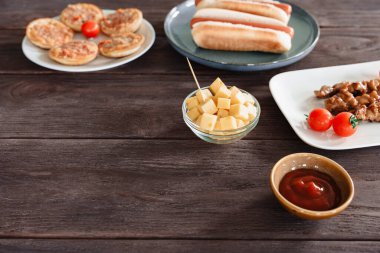 Bar ahşap masa peynir küpleri, sosisliler, mini pizzalar ve sos, bira ve şarap aperatifleri, fotokopi alanı.