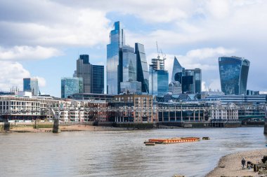 Londra şehrindeki gökdelenler Thames Nehri 'nin arkasından yükseliyor, kayıklar sürükleniyor ve insanlar kıyı boyunca yürüyor - 04.01.2024, İngiltere, Londra