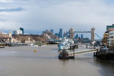 Londra 'daki Thames nehrine demirlemiş bir savaş gemisi, feribotlar 04.01.2024, İngiltere, Londra' dan geçerken Tower Bridge ile aynı hizada.