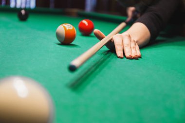 El bilardo masasını kavrıyor ve bilardo toplarının yanına ıstaka sopasıyla bir atış yapıyor. Kapalı bar oyunu