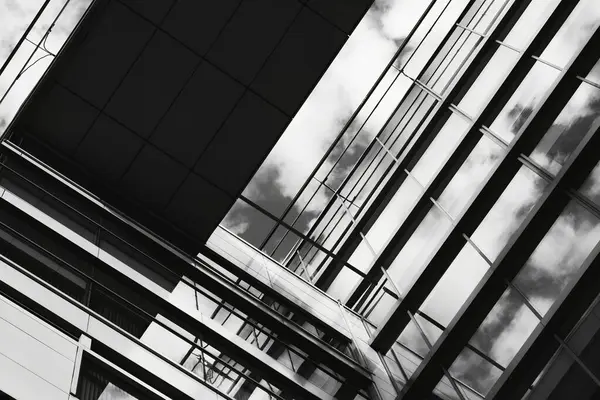 Aşağıdan görülen siyah beyaz modern cam bina, soyut geometri ve çizgiler, güçlü kontrast ve ışık oyunu