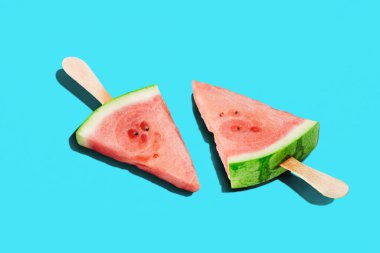 Iki karpuz kamışı, buzlu şeker biçiminde parlak mavi arka planda uzun gölgeler bırakır yaz serinlemesi, minimal yiyecek tasarımı