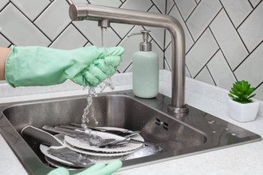 Plastik eldivenleri teslim et. Musluk suyunun altında süngeri sık ya da durula. Bulaşık yıkama, su sıçratma, ev işleri...