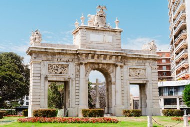 Valencia, İspanya - 07 Mayıs 2023: Barok zafer kemeri Puerta del Mar dini sembolizm ve çiçek yataklarıyla, tarihi turizm, Avrupa mimarisi