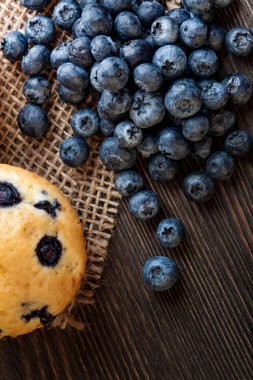 Ahşap bir masada yaban mersinli kek. Tahtada taze böğürtlen ve tatlı hamur işleri