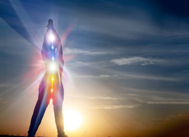 Yoga yapan kadın plaj günbatımı manzaralı, yedisi çakralı parlıyor. Kundalini enerjisi. Kız dışarıda meditasyon yapıyor. Siluet.