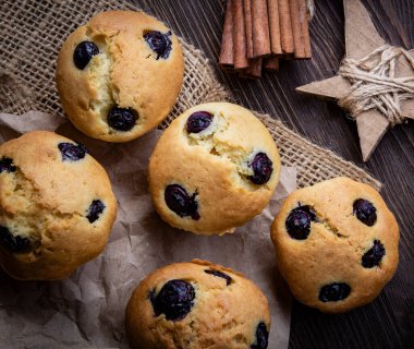 Ahşap bir masada yaban mersinli kek. Tahtada taze böğürtlen ve tatlı hamur işleri