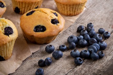 Ahşap bir masada yaban mersinli kek. Tahtada taze böğürtlen ve tatlı hamur işleri