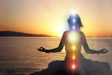 Yoga yapan kadın plaj günbatımı manzaralı, yedisi çakralı parlıyor. Kundalini enerjisi. Kız dışarıda meditasyon yapıyor. Siluet.