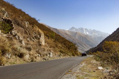 Yüksek dağlarda arabalı asfalt yol.