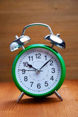 Klasik yeşil alarmlı saat ahşap bckground üzerinde sabah saati