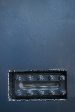 Arka planda vidaları olan metal fırçalı plakalar.