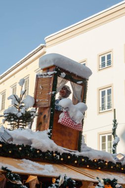 Rosenheim, Almanya - 03 Aralık 2023: çatıda Frau Holle ile birlikte durun ve Rosenheim 'daki Noel pazarında yatakları silkeleyin