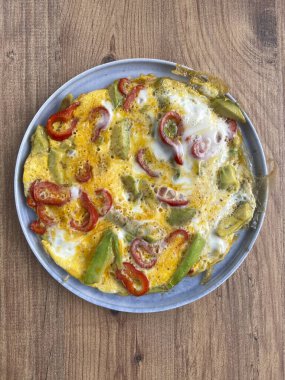 Kahvaltı için masada avokado ve kırmızı biberli lezzetli omlet. Sağlıklı kahvaltı ya da lezzetli avokado omleti ya da çırpılmış yumurta içeren yemek konsepti fotoğrafı.