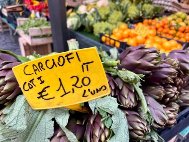 Pazar, İtalya 'da açık bir çiftçi pazarında seçici odaklı taze enginarların üzerinde İtalyan fiyat etiketi. Roma, İtalya 'da sebze standlarında taze ve olgun enginar ya da manavda sergileniyor. 