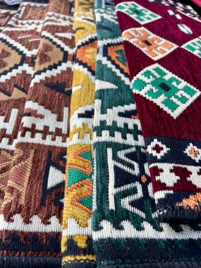 Türkiye 'de pazarda halı, katlanmış halılar ve geleneksel anadolu ve Türk tasarımları. Arkaplan olarak renkli halı yığını. Orta Doğu pazarında hediyelik eşya.