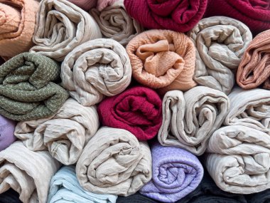 Arkaplan olarak eşarp, yığın ya da renkli pamuk kumaş ya da fular. Pamuk giysileri seçici odaklı bir tekstil ya da moda arka planı olarak katlanmış ya da katlanmış