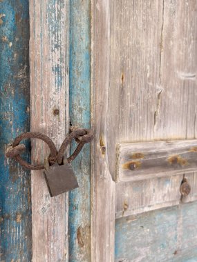Asma kilit, yakın plan eski paslı asma kilidi bir köy evinin ya da evinin kapalı ahşap kapısına asmış. Güvenlik konsepti ya da fotokopi alanı olan yüzey. Eski paslı kilidi ahşap kapıya asmış, terk edilmiş eve.