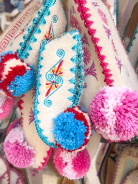 Yunanistan 'da bir hediyelik eşya dükkanında terlikler, asılmış renkli geleneksel Yunan yün terlikleri veya ev ayakkabıları. Arka plan olarak geleneksel yün çoraplar veya ayakkabılar. Yunanca hediyelik eşya dükkanı. 