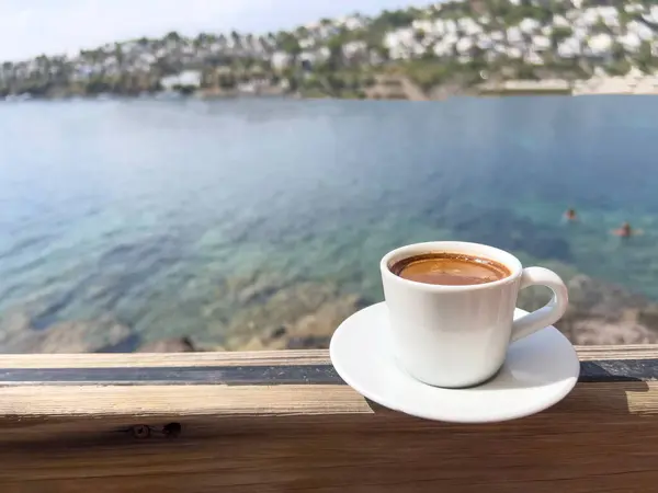coffee, cup of Greek or Turkish coffee on table over beautiful calm sea and sky with copy space in a sunny summer day in Turkey. traditional turkish hot drink or beverage. espresso cup over sea view