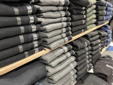 Alışveriş, mağazada satılık katlanmış giysiler. Mağazadaki raflarda yeni erkek giyim kıyafetleri ya da günlük pantolonlar. alışveriş kavramı arkaplan veya yüzey 