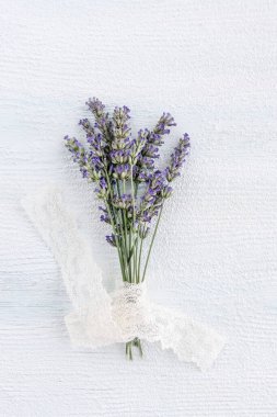 Çiçek, güzel demet lavanta çiçeği ahşap masa ya da arka planda dantel kurdeleli. Çiçek deseni. Ahşap arkaplanda ya da yüzeyde mor lavanta demeti. 