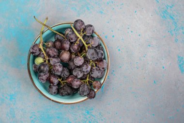Meyve, tabakta fotokopi alanı olan bir demet siyah üzüm. Sağlıklı yemek geçmişi. Siyah üzüm kümesi. Taze yaz meyvesi. Lezzetli taze yemek