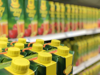 içecekler, bulanık süpermarket arka planı sarı ve yeşil meyve suyu ya da raflarda fotokopi alanı olan içecek kutuları. Piyasada doğal içecek yüzeyi. Kart kutusu. Doğal meyve suyu