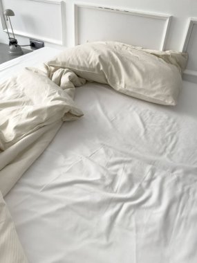 Dağınık yatak. Kullanılmış yastık, yapılmamış yatak örtüsü. Yatak odasındaki kırışık, dağınık battaniyeyle, uyumaktan. Otel odasında ya da yatak odasında buruşuk çarşaf, çarşaf ve yorgan..