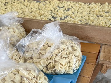 Orecchiette, el yapımı Apulian çiğ orecchiette makarna. Tipik İtalyan makarna tarifi. İtalya 'nın tarihi merkezi Bari' nin yaşlı İtalyan bayanları tarafından üretilen ve satılan torbalar dolusu orkide.. 