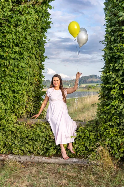 Pregnant Woman Balloons Sits Arch Made Green Leaves — Stock Photo, Image