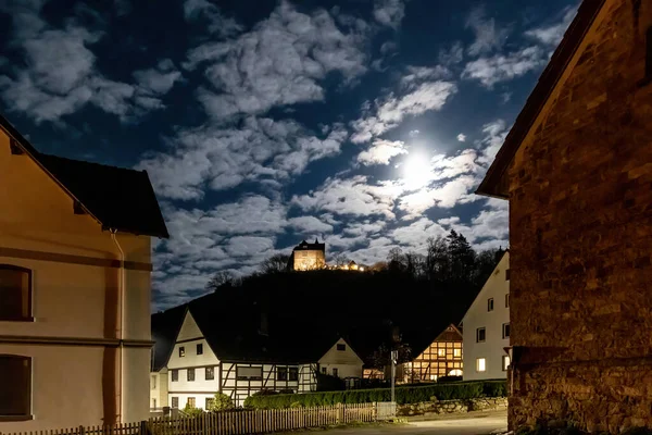 Moonlit night in an old German town, cloudy sky and full moon