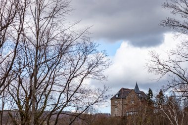 Yalnız ev, gökyüzünün arka planında bulutlu bir dağda duruyor.
