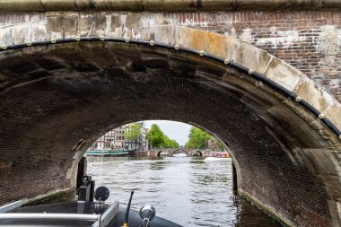 A ship sails under a bridge in Amsterdam, Netherlands